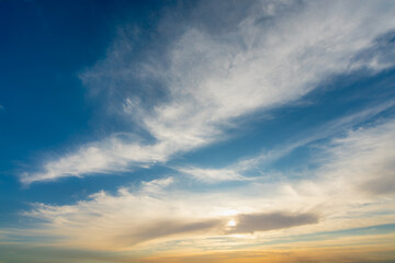 Obraz premium A vibrant and dramatic sky with wispy clouds, showcasing the transition from bright blue to a warm, golden hue as the sun sets. The photo was taken during a Nile cruise near Luxor and Esna.