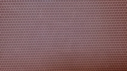 close-up of perforated brown leather surface with uniform circular holes for automotive upholstery or luxury furniture design