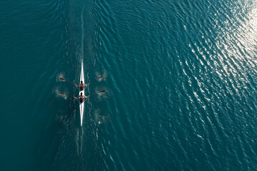 Two synchronized rowers glide across calm water in perfect aerial symmetry