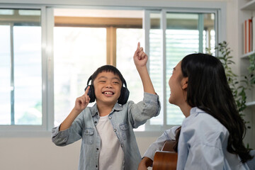 Fototapeta premium Excited child dancing to music. Young boy with headphones enjoying a lively moment.
