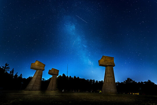 Milky way over a memorial park Bubanj in Nis, Serbia. Built in 1963, is dedicated to victims of fascism in the second world war. The three fists rising from the ground envisioning both a vengeance for