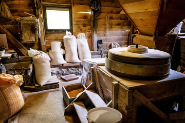 Inside the old wooden flour grinding mill. Interior of retro wooden watermill with old equipment for grinding or milling grain into flour