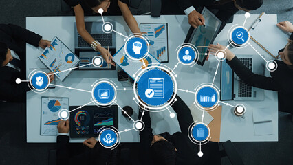 A diverse group of professionals collaborates in a modern office environment, analyzing digital data visualizations on laptops and tablets while brainstorming strategies. Amity