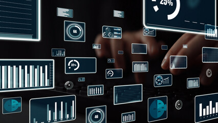 A modern workspace featuring hands typing on a keyboard, surrounded by numerous data visualization...