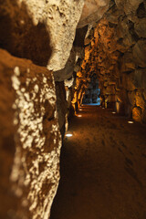 Interior stone corridor inside prehistoric Nuraghe in Sardinia illuminated by warm spotlights