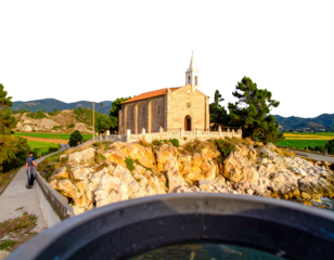 Pilgrim walking toward church on hilly landscape  