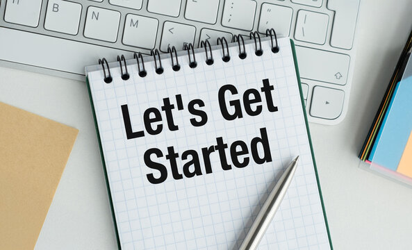A notebook with the words Let's Get Started written on it
