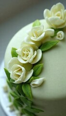 Obraz premium Elegant cake decorated with white rose fondant and green leaves in an artistic presentation