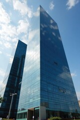 Obraz premium Two modern skyscrapers reflecting a partly cloudy sky.