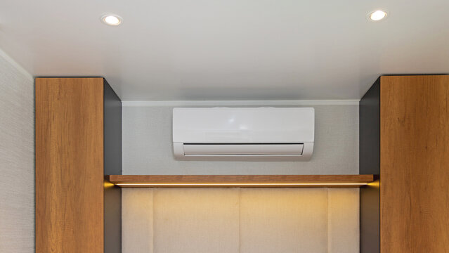 White Air Conditioner Mini Split Unit Mounted at Wall in Bedroom
