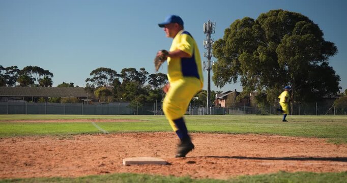 On throw first baseman in yellow is tagging sliding runner at base on diamond for out