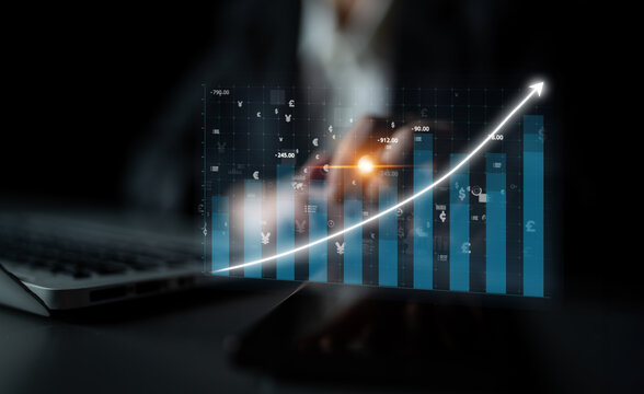 A digital growth chart overlaying a laptop depicts business progress in a dark setting, showcasing professional data analysis and upward performance trends. Impute