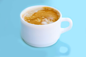 Minimalist white cup filled with espresso and soft crema on pastel blue background