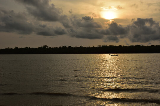 Silhouetted Boat on a River at Sunset