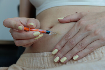 A Close-Up View of a Person Preparing to Inject Medication into Their Abdomen with a Syringe, Signifying Health Care and Medical hormonal stimulation of the ovaries Procedures