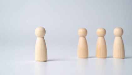 One wooden figure stepping forward while others follow, movement concept. Community, leadership