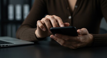 Professional Businesswoman Hands Using Smartphone at Dark Wood Desk, Person in Brown Cardigan Scrolling Through Financial Data or Business News on Mobile App
