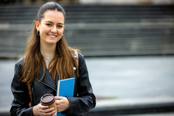 Fototapeta premium Female Student with Book and Coffee on College Campus