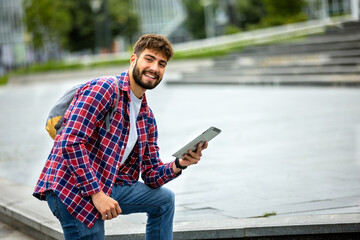 Obraz premium Male Student Using Tablet on College Campus