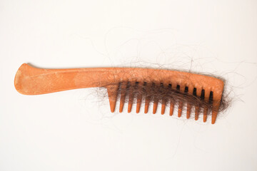 Fallen hair on plastic comb, white background