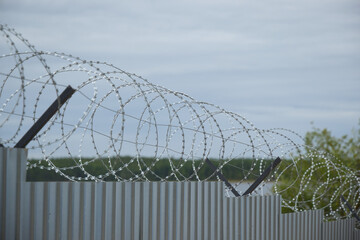 A Barbed Wire Fence Surrounding an Industrial Area, Serving as a Secure Boundary for Safety