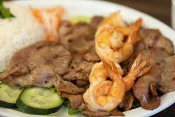 Grilled shrimp and pork rice plate with cucumber and pickled vegetables