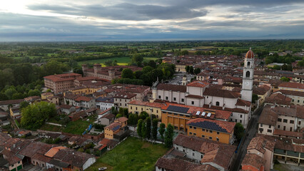 Fototapeta premium Majestic aerial view of Pontevico BS Italy showcasing its historic architecture and surrounding verdant landscape under a dramatic sky