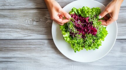 Top-down view of white plate with fresh salad and homegrown herbs, hand placing garnish, clean healthy composition