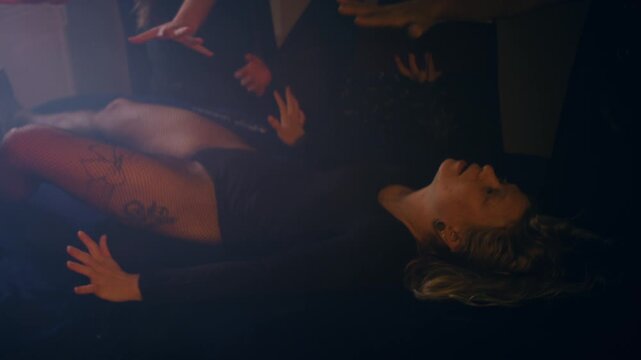 a writhing woman is sacrificed on an altar during a satanic ritual