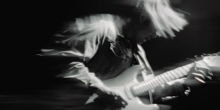 Blonde Young Male Guitarist Playing an Electric Guitar on 16mm Black and White Blurred Film Footage