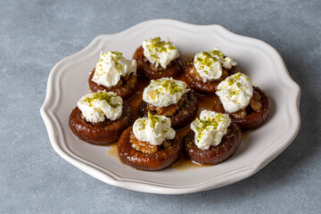 Stuffed dry fig dessert, cooked with syrup, traditional, pistachio and kaymak (Turkish name; kaymakli incir tatlisi )