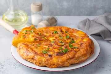 Spanish omelette with potatoes, typical spanish cuisine on gray concrete floor. Tortilla Espanola. Turkish name; Yumurtali patates