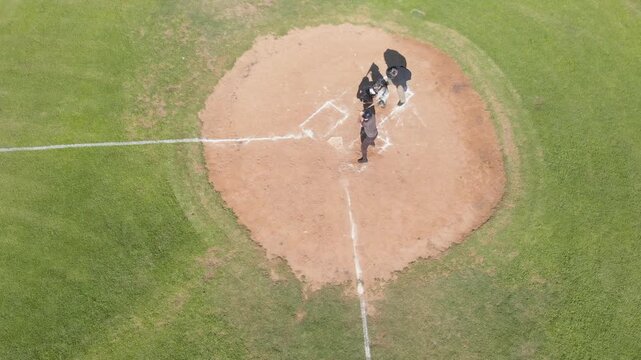 Pitched ball arriving, white male batter swinging bat, bat slipping, running to 1st base on diamond