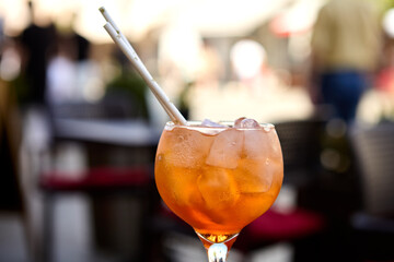 Two Aperol spritz cocktails served at an outdoor cafe table