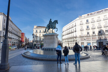 Plaza View: Capturing the spirit of city, the statue in the heart of the plaza. The sky, buildings, and people evoke a sense of urban life and history.