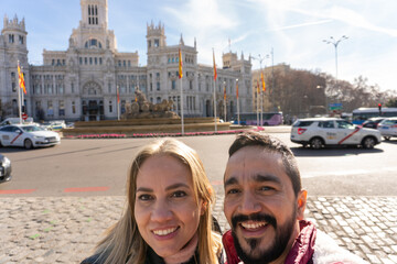 City Exploration: A couple smiling gleefully pose in front of a stunning architectural marvel. A dynamic portrayal of exploration and tourism.