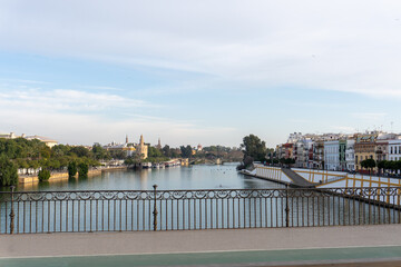 Scenic river in Seville, Spain: A panoramic view of a river flowing gracefully through the heart of...