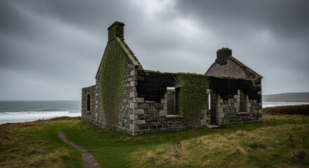 Fototapeta premium Weathered Stone Ruins of a Coastal Cottage Under a Gloomy Sky with Ocean