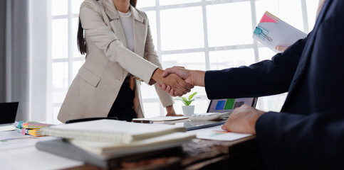 Happy financial advisor Banker and client shaking hands after business loan grant.
