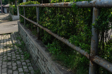 Rusty Metal Railing and Green Foliage in Outdoor Setting