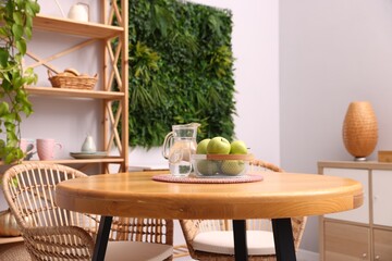 Wooden table with chairs and decor in stylish dining room, closeup. Interior design