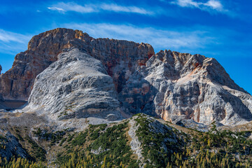 Fototapeta premium Stunning panoramic view of a massive mountain, with colorful rock formations and a forest in the foreground.