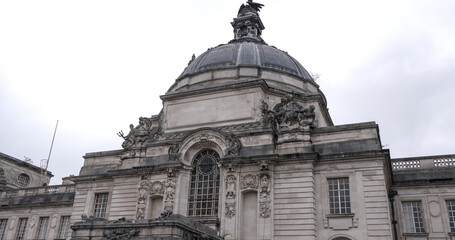 Impressive sculptures and dome of Cardiff City Hall against a cloudy sky, showcasing Welsh architecture