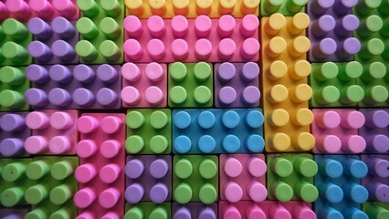 A close-up view of vibrant plastic toy building blocks in various pastel colors neatly aligned, emphasizing texture and pattern.
