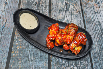 Double-fried Korean-style chicken wings glazed with sweet and spicy gochujang sauce, garnished with sesame seeds.