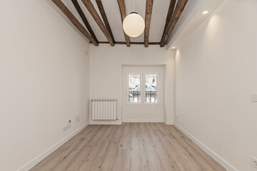 Empty room in a renovated old farmhouse, with a complex system of perfectly preserved tea wood beams