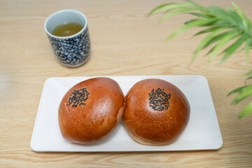 テーブルに置いた和菓子のあんぱんと日本茶