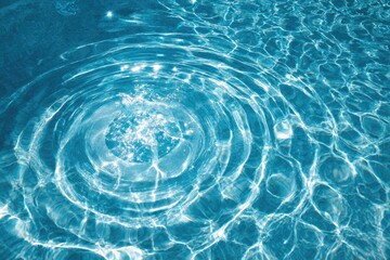 Ripples in a turquoise pool water. Sunlight sparkles on the surface