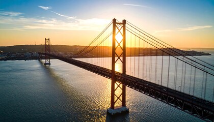 Fototapeta premium Scenic sunrise over a suspension bridge spanning a body of water.