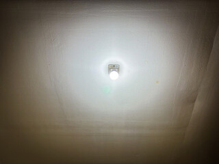 Cracked ceiling with glowing light bulb